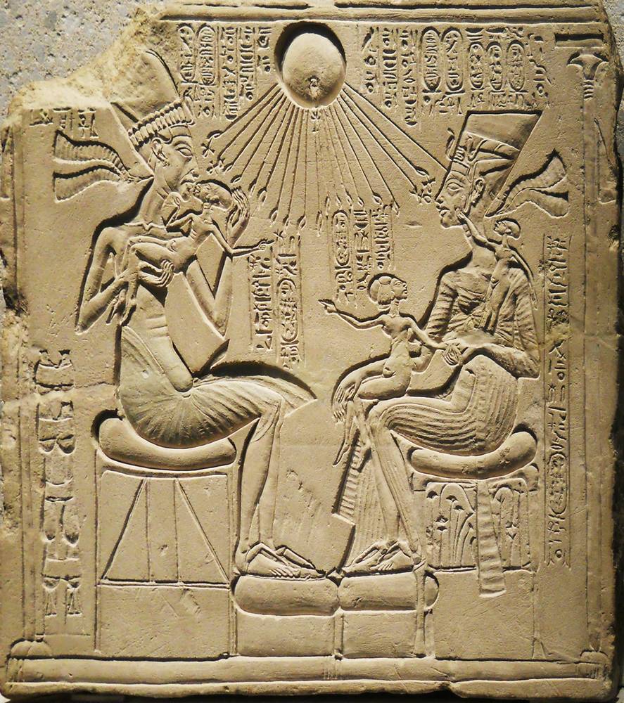 Le dieu-soleil égyptien Aton fait descendre ses mains en rayons sur Akhenaton et Néfertiti avec trois enfants. Public Domain